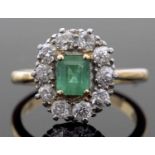 Emerald and diamond cluster ring, the stepped cut rectangular emerald within a diamond surround,