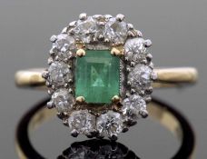 Emerald and diamond cluster ring, the stepped cut rectangular emerald within a diamond surround,