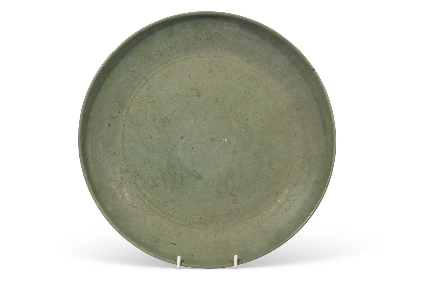 Asian green glazed pottery dish, indistinctly decorated to the centre with an elephant, 31cm diam