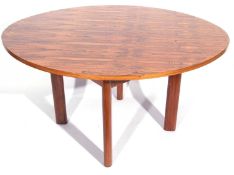 A mid century Rosewood extending dining table with oval top opening to reveal internal extention
