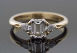 Three-stone diamond ring, the centre set with an emerald cut diamond, 5.38 x 4.02 x 2.61mm,