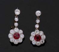 Pair of ruby and diamond drop earrings comprising a cluster of a cushion faceted ruby surrounded