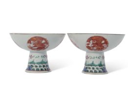 Pair of Chinese porcelain stem cups, late Qing dynasty, decorated in iron red with phoenix to the