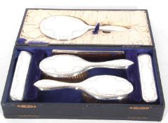 Cased George V silver backed dressing table set comprising hand mirror, two hair brushes, two