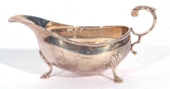 Elizabeth II silver sauce boat, features a beaded border and an acanthus detail handle, supported on