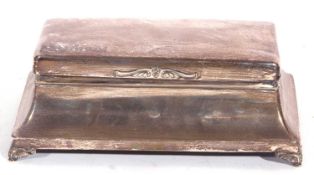 George V silver table cigarette casket of plain polished rectangular form, having a small scroll