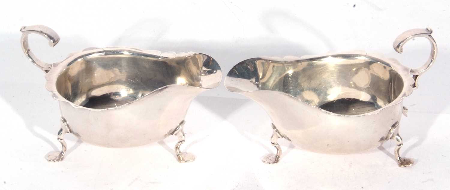 Two George VI sauce boats with card cut rims, flying scroll capped handles and supported on three - Image 2 of 4