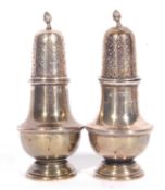 Pair of George V silver peppers of baluster form, having pierced detachable lids with urn finial,