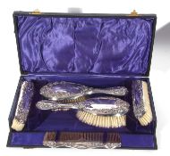 Cased George V silver backed dressing table wares to include two hair brushes, framed comb,