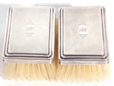 Pair of George VI silver backed clothes brushes, each with a central rectangular engraved cartouche,