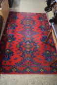 20TH CENTURY FLOOR RUG DECORATED WITH GEOMETRIC DESIGN ON A RED BACKGROUND, 213CM LONG