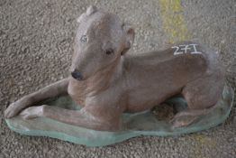 Composite garden ornament modelled as a dog, length approx 65cm