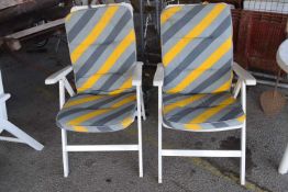 Pair of white plastic sun loungers