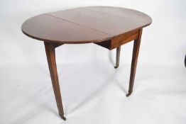 Late 19th century mahogany oval drop leaf table raised on tapering legs with brass end caps and