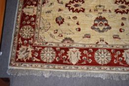 Contemporary floor rug decorated with large beige central panel and red border with floral
