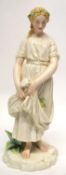 Royal Worcester style Art Nouveau model of a maiden or flower seller, on rocky base, 32cm high