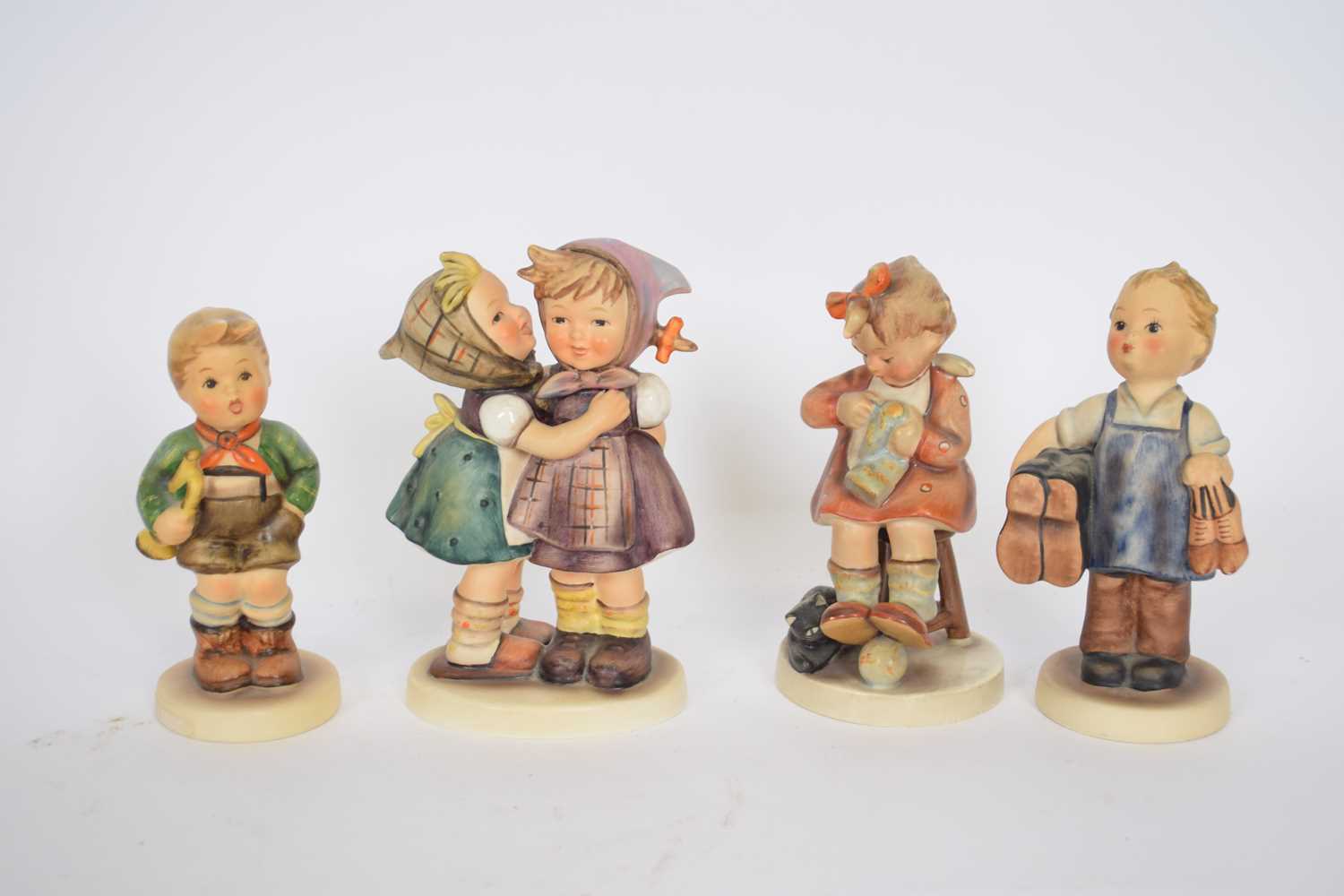 Group of four Goebel figures of children, designed by Hummel, including Boots and others (4)