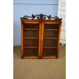 Small 19th century mahogany two-door bookcase cabinet with floral pediment over two glazed doors