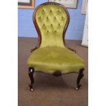 Victorian spoon back nursing chair with green upholstered buttoned fabric, raised on short