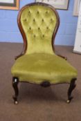 Victorian spoon back nursing chair with green upholstered buttoned fabric, raised on short