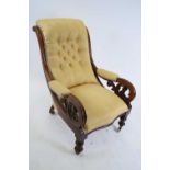 Victorian mahogany framed scroll arm chair upholstered in yellow buttoned fabric, raised on turned