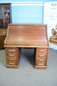 Late 19th/early 20th century oak roll front twin pedestal desk, the top section with fitted interior