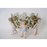Continental porcelain flower vase supported by four cherubs, the bowl with floral decoration in
