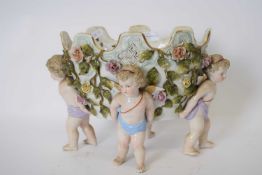 Continental porcelain flower vase supported by four cherubs, the bowl with floral decoration in