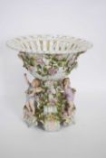 Large late 19th century Continental porcelain centrepiece, the bowl supported by three cherubs on