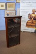 Early 20th century mahogany corner cabinet with single astragal glazed door and shelved interior,