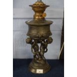 Oil lamp, the lamp decorated with cherubs in spelter, on raised circular base, 30cm high