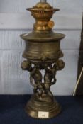 Oil lamp, the lamp decorated with cherubs in spelter, on raised circular base, 30cm high