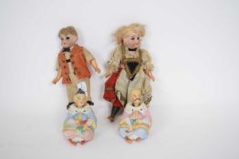 Pair of Oriental ceramic nodding dolls, together with two further small dolls with bisque painted