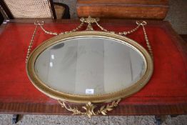 OVAL BEVELLED WALL MIRROR SET IN A FRAME WITH URN AND GARLAND MOUNTS, 70CM WIDE