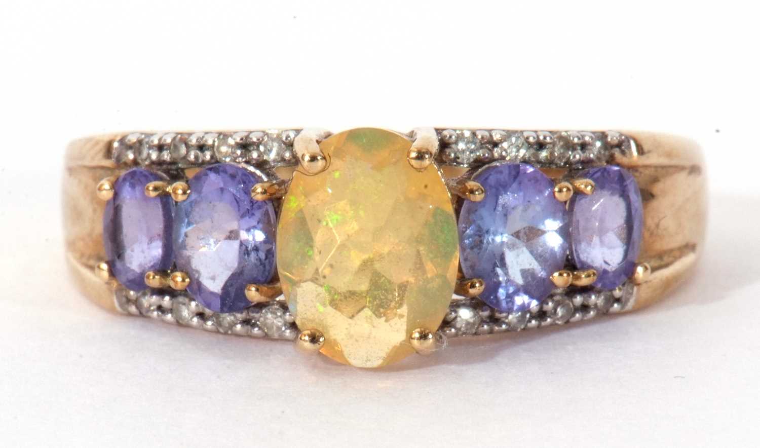Modern 9ct gold, opal, tanzanite and diamond ring, the oval cut opal raised above a tanzanite and