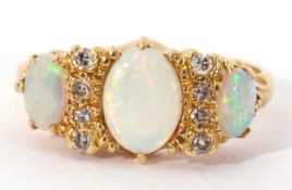 18ct gold opal and diamond ring featuring three graduated oval shaped opals, highlighted between