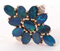 Modern 9ct gold black opal doublet dress ring, a lozenge design set with 11 opals, raised between