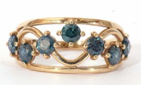 Modern 9ct gold and blue stone ring, the open work scroll mount set with seven round cut blue