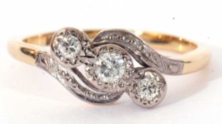 Three stone diamond cross-over ring, having three graduated round cut diamonds, each in illusion