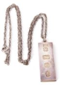 Silver ingot pendant with oversized hallmarks for London 1977, suspended from a metal fancy link