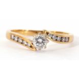 18ct gold single stone diamond ring centring a round brilliant cut diamond raised between small