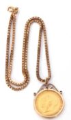 George V gold sovereign framed in a 9ct gold scroll pendant mount suspended from a 9ct gold box link