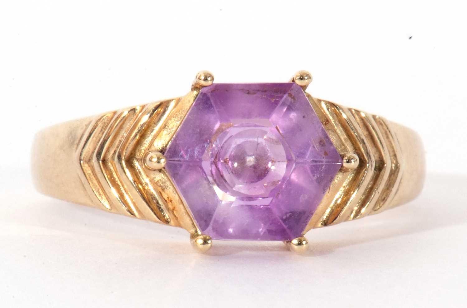 Modern 9ct gold and purple crystal ring, the hexagonal purple stone raised between engraved