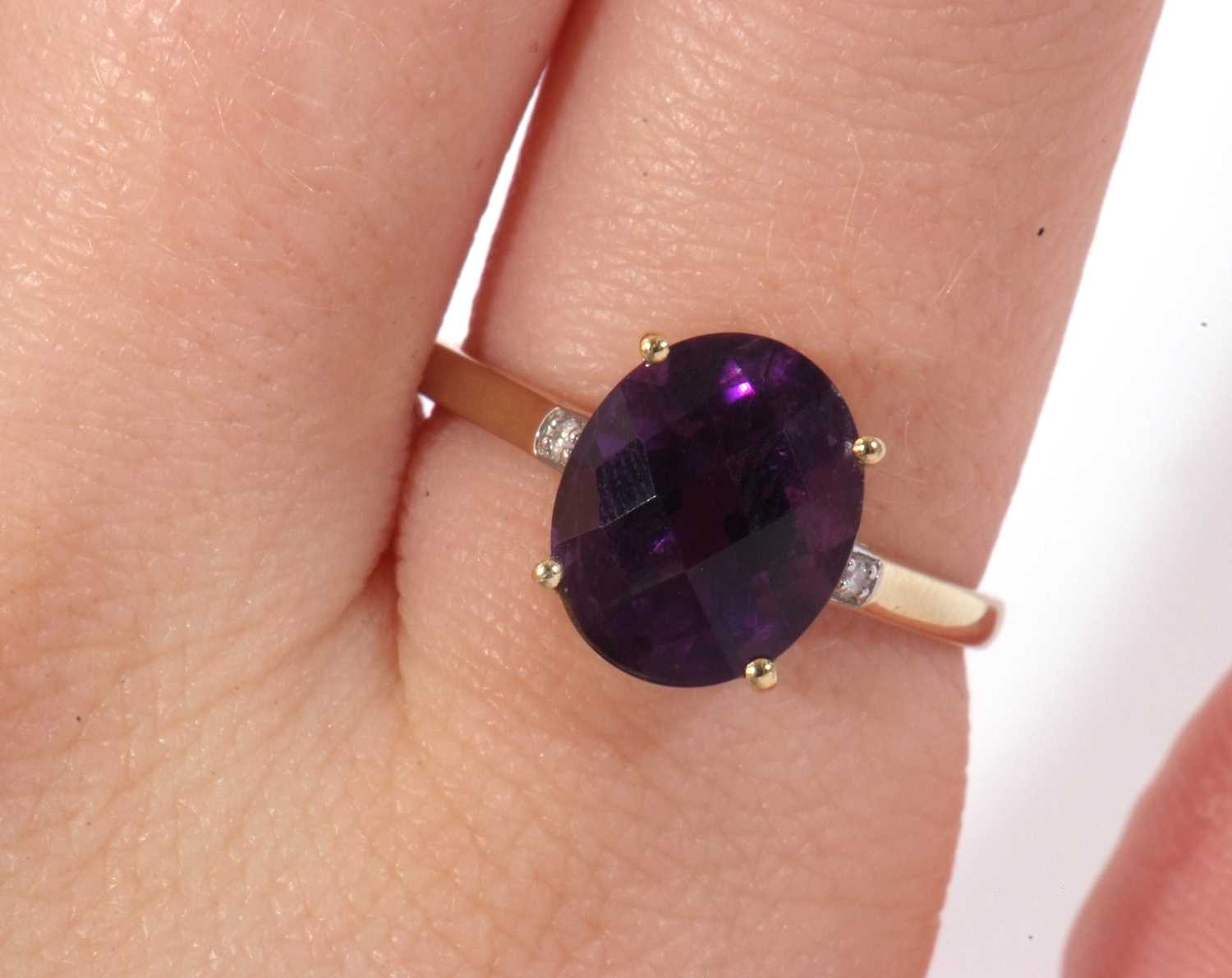Modern 9ct gold amethyst and diamond ring, the oval faceted amethyst basket set and raised between - Image 9 of 9