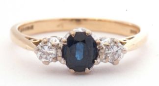 18ct gold sapphire and diamond three stone ring centring an oval faceted sapphire between two