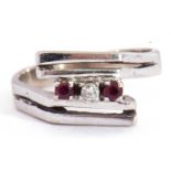 Precious metal stylised small ruby and diamond ring of angular design, highlighted with a small