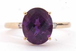 Modern 9ct gold amethyst and diamond ring, the oval faceted amethyst basket set and raised between