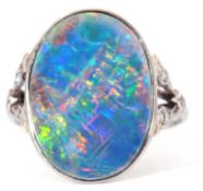 Opal and diamond ring, the oval shaped flat opal bezel set and raised between small diamond set