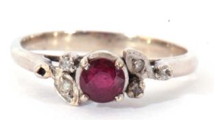 Precious metal, ruby and diamond ring centring a small round faceted ruby raised above small mixed