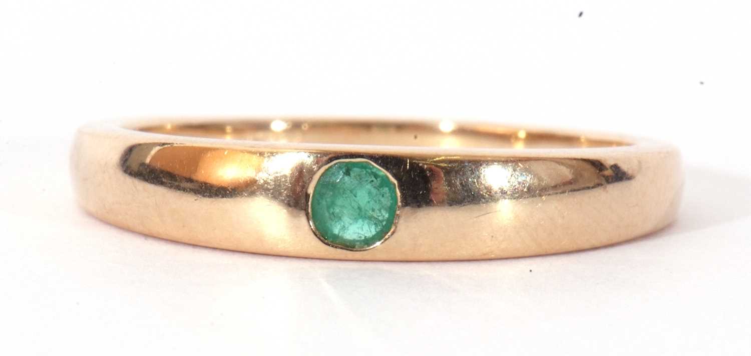 Modern 9ct gold single stone emerald ring, the plain polished band centring a flush set small